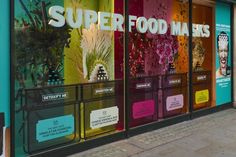 a store front with colorful glass windows and advertisements on the side of it's doors