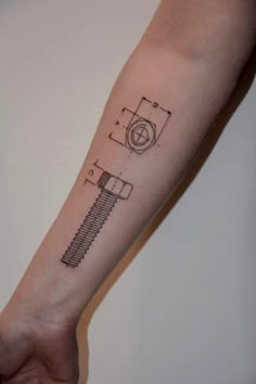 a person's arm with a tattoo on it that has an image of a wrench