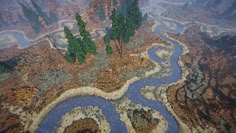 an aerial view of a river running through a mountain range with trees in the foreground