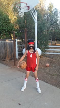 a man dressed as a basketball player holding a basketball in front of a basket ball hoop