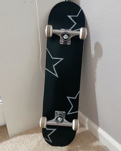 a black skateboard leaning against the wall