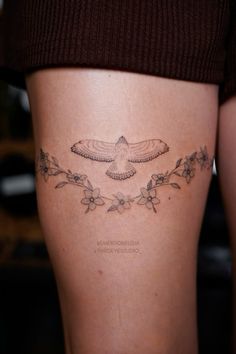 a woman's thigh with a humming tattoo on it