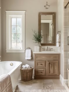 a bath room with a tub a sink and a mirror on the wall next to a window