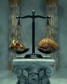 a scale with two gold pieces on it and a brain sitting on top of one