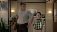 a man standing next to a boy in a hallway