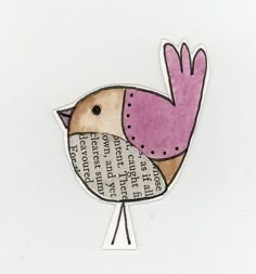 a small bird with pink and brown feathers sitting on top of a piece of paper