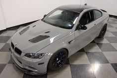 a silver car is parked on a black and white checkered floor