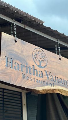 a sign hanging from the side of a building that says hartina - vanam restaurant
