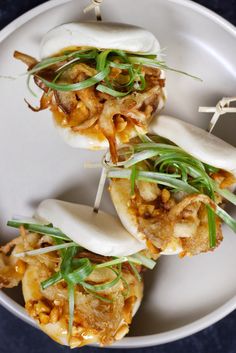 some food is on a white plate with green garnish and toothpicks