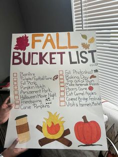 a person holding up a fall bucket list