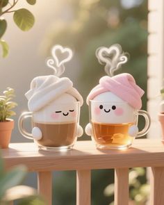 two coffee cups with faces drawn on them sitting next to each other in front of some potted plants