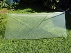 a green tarp sitting on top of a lush green field