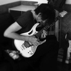 black and white photograph of a man playing an electric guitar