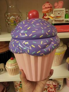 a cupcake with sprinkles and a cherry sitting on top of it