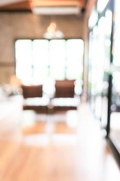 blurry image of an empty room with couches and chairs in the back ground