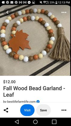 a wooden bead garland with an oak leaf on it and a tassel hanging from the front