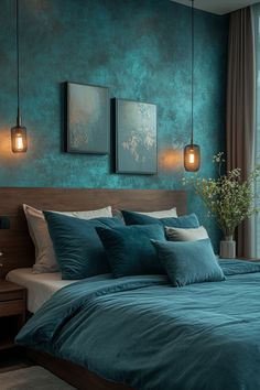 a bedroom with teal colored walls and blue bedding, two hanging lights above the bed