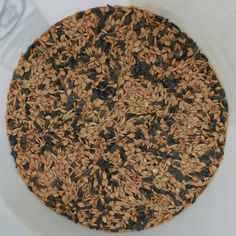 a white bowl filled with lots of brown and black rice on top of a table