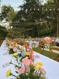 a long table is set up with flowers and place settings for guests to sit at