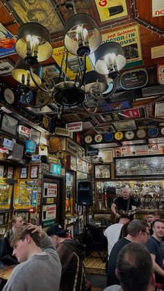 a group of people sitting at tables in a room with many signs on the ceiling