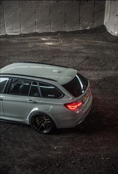 a silver car parked on top of a dirt field