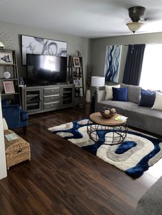 a living room filled with furniture and a flat screen tv on top of a wooden floor
