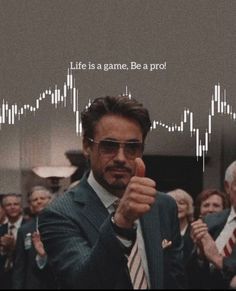 a man pointing to the camera in front of a group of people