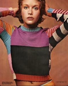 a woman with her hands on her head wearing colorful sweaters and shorts, posing for a magazine cover