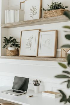 a laptop computer sitting on top of a white desk next to a potted plant