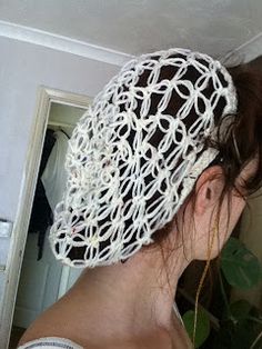 a woman wearing a white crochet head covering