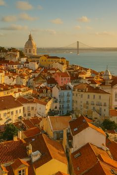an aerial view of a city with buildings and a bridge in the background, taken from above