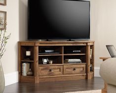 a flat screen tv sitting on top of a wooden entertainment center in a living room
