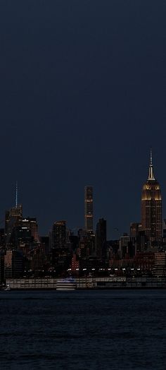 the city skyline is lit up at night with bright lights on it's skyscrapers