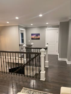 an empty living room with wood floors and white railings
