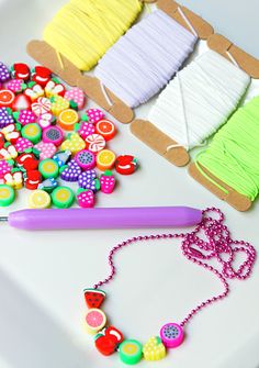 the craft supplies are laid out on the table to be used for making necklaces