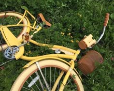 a yellow bicycle is parked in the grass