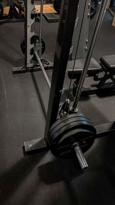 an empty gym with weight machines and barbells