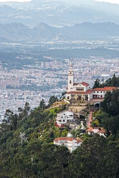 a large white building sitting on top of a lush green hillside