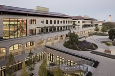 an aerial view of a building with many windows and plants in the courtyard at dusk