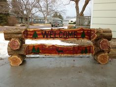 a log bench made to look like a welcome sign