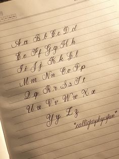 an open notebook with cursive writing on it