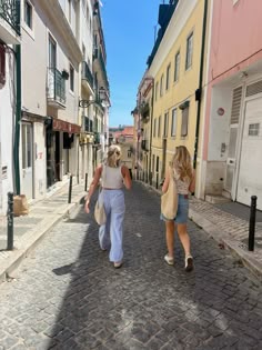 two women are walking down the street with their dog