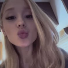 a close up of a person making a face with her mouth open and tongue out