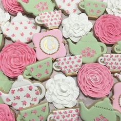 there are many decorated cookies in the shape of teapots and roses on display