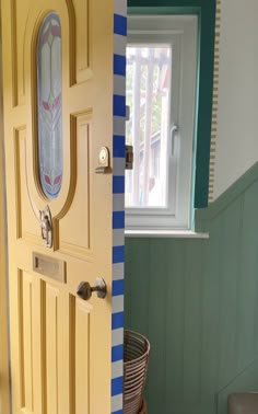 the door is painted yellow and has blue stripes on it, along with a basket