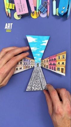 someone is making a paper art project with colored pencils