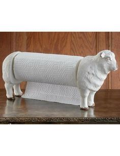 a white sheep figurine sitting on top of a wooden table