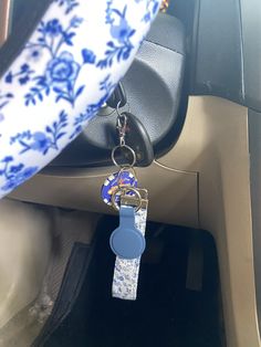 a blue and white keychain hanging from the front seat of a car,
