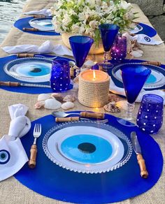 the table is set with blue plates and place settings