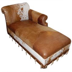 a brown and white leather chaise lounge chair with cowhide trimmings on the back